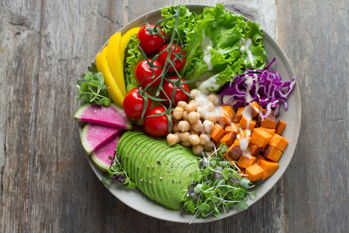 Nutritious foods including vegetables, fish, and herbs displayed on a table